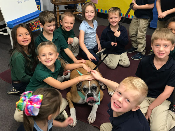 Young students petting a dog.